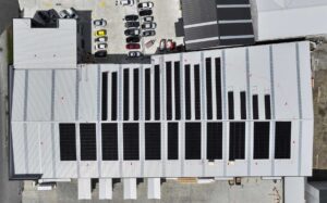 Close-up aerial perspective of the 594-panel solar array installed at Truss Tech Cromwell, illustrating panel layout and rooftop coverage under bright daylight